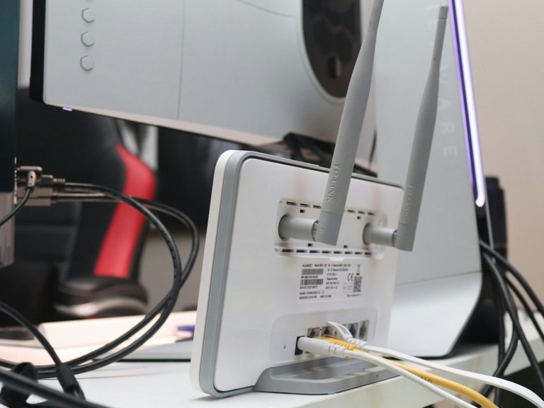 AMK IT Solutions A router with antennas and multiple cables connected at the back.